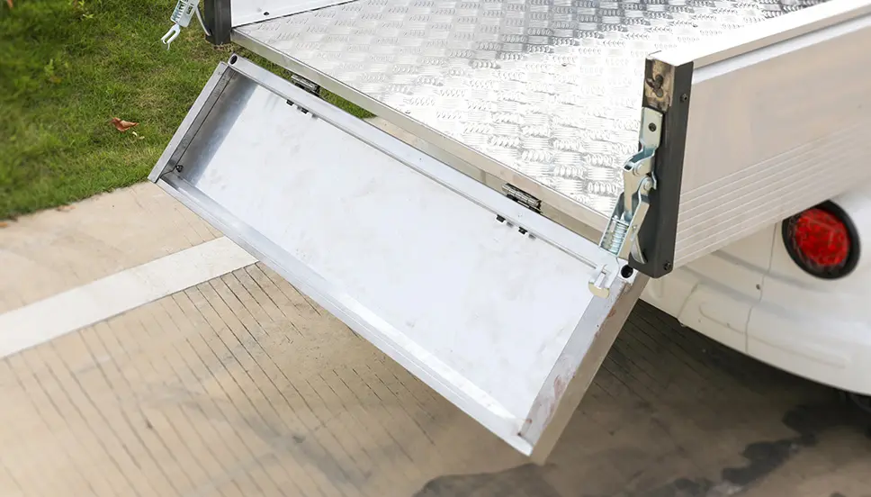Foldable Aluminum Tailgate for Convenient Loading and Unloading. Foldable aluminum tailgate of a utility e-cart in the open position for easy access.