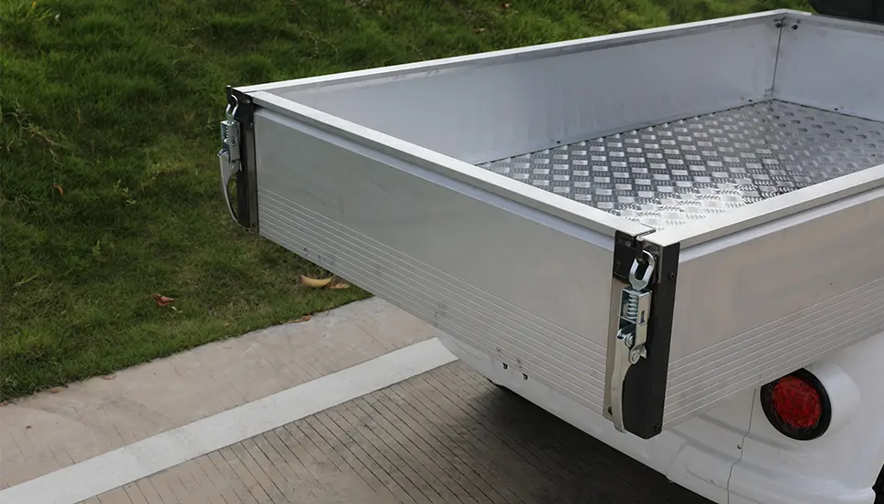 Spacious Aluminum Cargo Bed for Versatile Transport Solutions. View of a spacious aluminum cargo bed on a utility e-cart, showcasing its ample storage capacity.