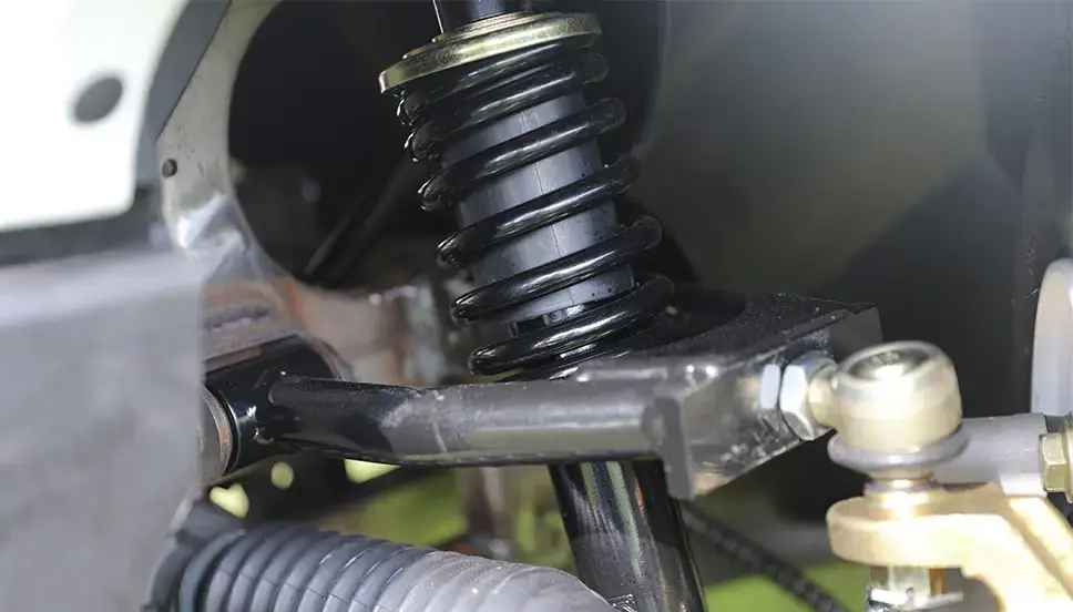 Heavy-Duty Front Suspension for Enhanced Stability and Comfort. Close-up of the heavy-duty front suspension system in a utility e-cart.
