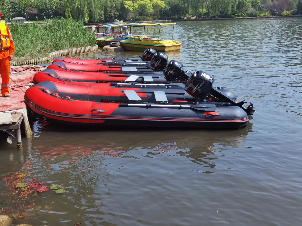 Inflatable Boats at the Lake A series of red and black inflatable boats lined up